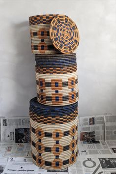 several stacks of woven baskets stacked on top of each other in front of newspapers and magazines