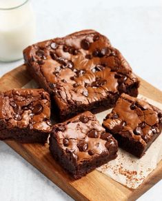 chocolate brownies on a cutting board next to a glass of milk