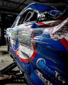 the front end of a race car painted in red, white and blue