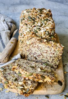 sliced loaf of granola bread sitting on top of a cutting board