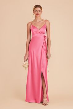 a woman in a long pink dress with a slit down the side and her hand on her hip