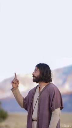 jesus pointing to the sky with mountains in the background