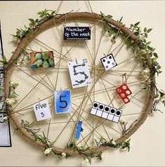 a wheel made out of branches with magnets and numbers on it, hanging from the wall