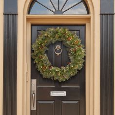 a christmas wreath on the front door of a house