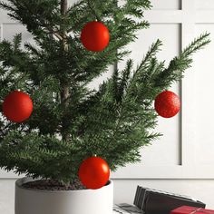 a small christmas tree with red balls on it