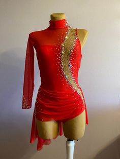 a mannequin is wearing a red dress with gold sequins on it