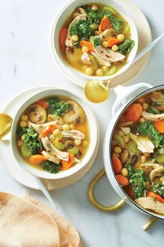 two white bowls filled with soup and vegetables