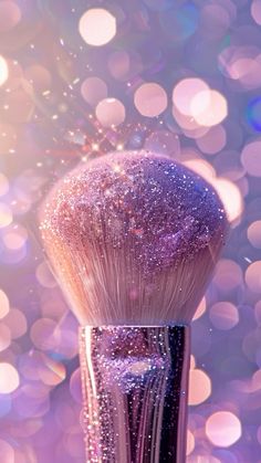 a close up of a purple makeup brush with glitter on it's head and the background is blurry