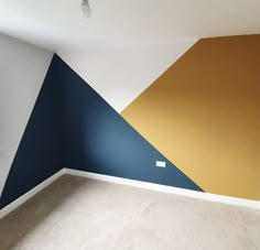 an empty room with blue, yellow and white painted on the wall in it's corner