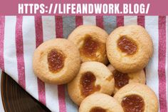 some cookies with jam on them sitting on a plate