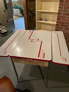 two tables with red and white lines on them in a room next to a brick wall