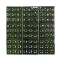 green glass tile with circles and dots on the bottom, set against a white background