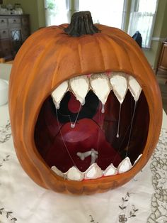 a carved pumpkin with its mouth open on a table