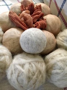 a pile of wool balls sitting on top of a couch next to a piece of cloth