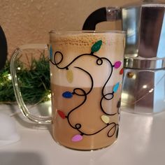 a coffee mug with christmas lights on it