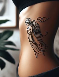 a woman's stomach with an angel tattoo on it