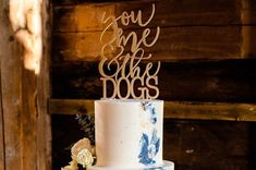 a white and blue wedding cake with the words you are the dogs on it