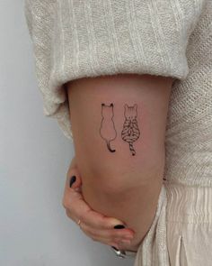 a woman with a small tattoo on her stomach shows the outlines of two cats and a dog