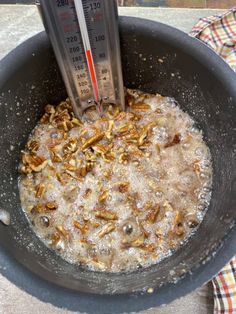 a large bowl filled with food next to a thermometer on top of a table