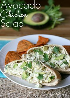 a white plate topped with chicken salad and tortilla chips on top of a table