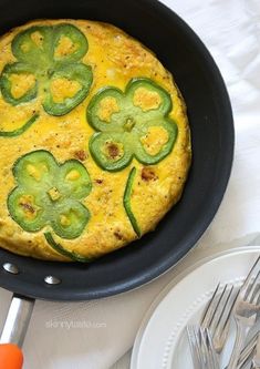 an omelet with green peppers and cheese in a skillet on a table