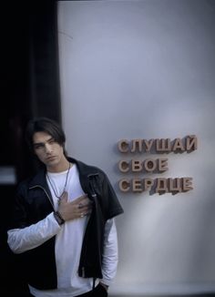 a young man standing in front of a sign