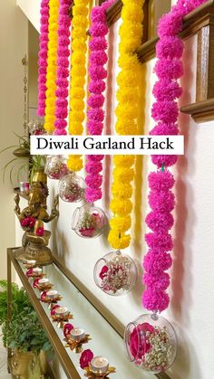 colorful garlands are hanging on the wall next to vases with flowers in them