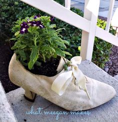 a pair of shoes with flowers in them sitting on the steps next to a fence