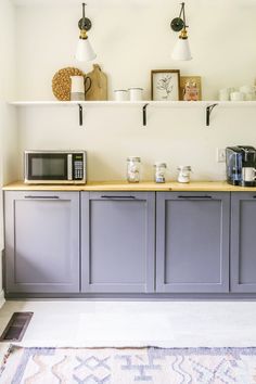 a kitchen with gray cabinets and white walls