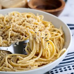 a white bowl filled with pasta and parmesan cheese