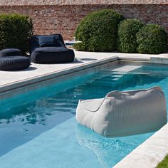 an outdoor pool with lounge chair and bean bag