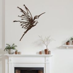 a living room filled with furniture and a fire place under a metal bird wall sculpture