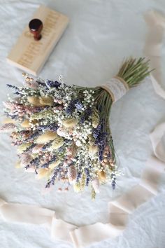 a bouquet of flowers sitting on top of a white table cloth next to a book