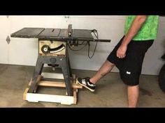 a man standing next to a table sawing machine