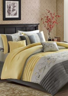 a bed with yellow and gray comforters in a bedroom