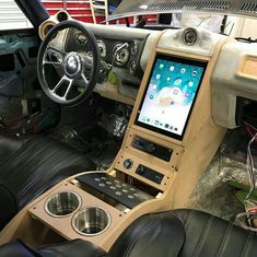 the inside of a car with an electronic device in the dash board and steering wheel