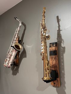 there are two saxophones on the wall next to each other and one is hanging