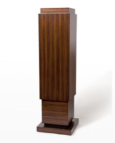 a tall wooden object sitting on top of a white surface