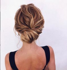 a woman with her back to the camera wearing a black tank top and braided hair