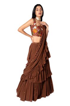 Brown pre-stitched saree with layered ruffle and sequin embroidered detail. Paired with floral embroidered blouse.
Component: 2
Embroidered
Neckline: Square
Sleeve Length: Sleeveless
Fabric: Raw Silk, Georgette
Color: Brown
Ruffle border - Aza Fashions Ruffle Sarees, Stitched Saree, Ruffle Saree, Drape Saree, Embroidered Neckline, Blouse For Women, Fashion App, Blouse Online, Neck Ruffle