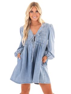 Unleash your inner denim diva with our Blue Jean Beauty Denim Romper! This playful romper features a pleated front with a trendy tie detail, along with convenient pockets for all your essentials. And with a deep v-neckline, you'll be turning heads wherever you go. Time to rock that denim look in style! Trendy V-neck Denim Dress For Day Out, Trendy V-neck Denim Jumpsuit For Spring, Trendy V-neck Denim Jumpsuit For Summer, Denim Blue V-neck Dress For Fall, Trendy V-neck Denim Dress, Fall V-neck Denim Blue Dress, Fall Denim Blue V-neck Dress, Trendy Spring V-neck Denim Dress, V-neck Denim Dress With Pockets For Day Out