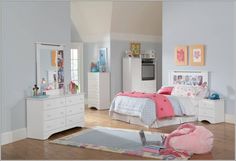 a bedroom with white furniture and pink accessories on the bed, dressers and mirror