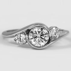 three stone engagement ring with diamond accents in white gold and diamonds on the band, set against a plain background