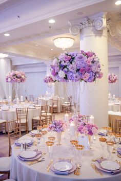 the tables are set with purple and white flowers