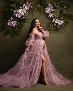 a woman in a purple dress posing for a photo with flowers around her neck and legs