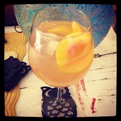 a close up of a drink in a glass on a table with an orange slice