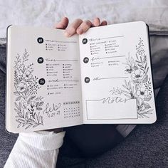 a person is holding an open notebook with flowers on it and the pages are lined up