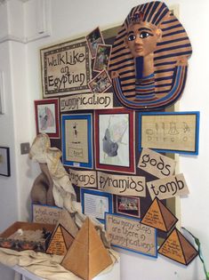 an egyptian themed wall hanging with pictures and pyramids on the wall next to it