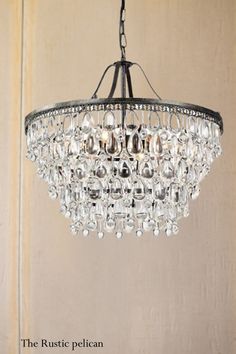 the rustic pelican chandelier is made from metal and features crystal drops