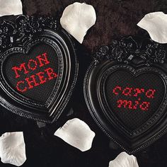 two heart shaped tins with the words mom and child written on them, surrounded by white petals